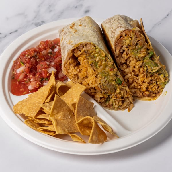 Two large burritos, cut in half, with a side of salsa and tortilla chips on a white plate.