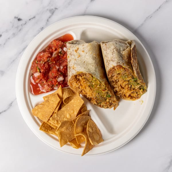 Two burritos cut in half, with salsa and tortilla chips on a white plate.